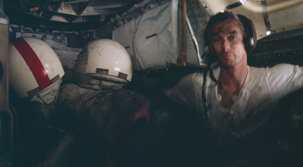 Apollo 17 Lunar Module cabin interior after day 3 on the lunar surface: Helmets and space suits on the engine cover at left with Astronaut Gene Cernan looking on.  (Credit: NASA)